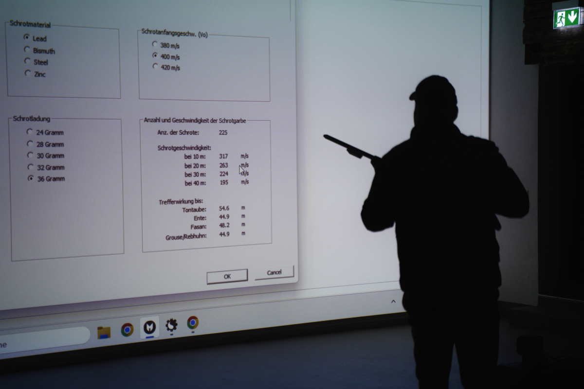 Schießkino – Simulation bewegter Wildtiere. Ansicht auf einen Jäger, welcher auf eine Ansicht mit einstellungen schaut.
